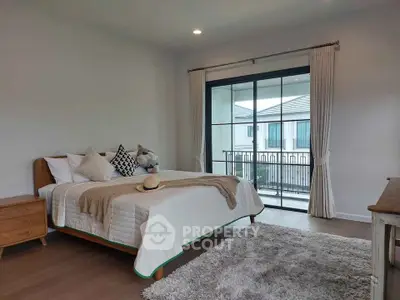 Spacious bedroom with modern decor and balcony view in a stylish home.
