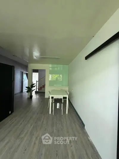 Spacious modern interior with sleek flooring and minimalist dining area, ideal for contemporary living.