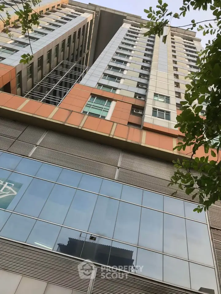Modern high-rise building exterior with glass facade and contemporary design.