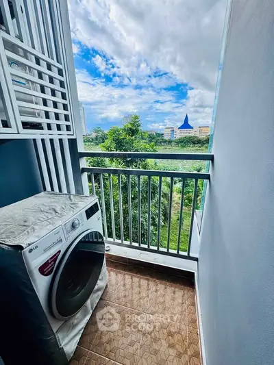Charming balcony with lush green view and modern washing machine, perfect for urban living.