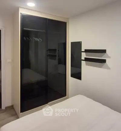 Modern bedroom with sleek mirrored wardrobe and minimalist decor