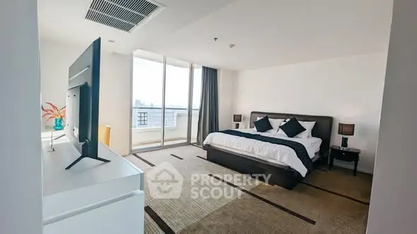 Spacious modern bedroom with large windows and city view, featuring elegant decor and ample natural light.