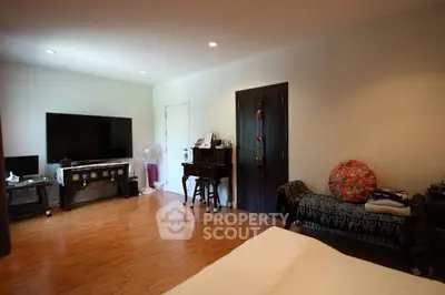 Spacious bedroom with wooden flooring and modern decor