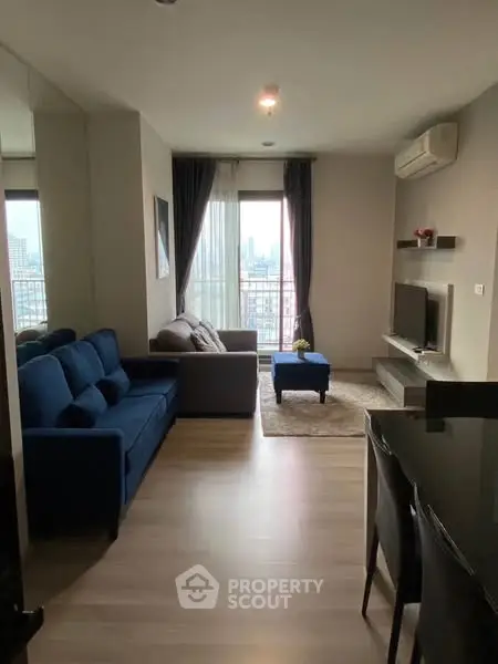 Modern living room with city view, stylish furniture, and natural light.