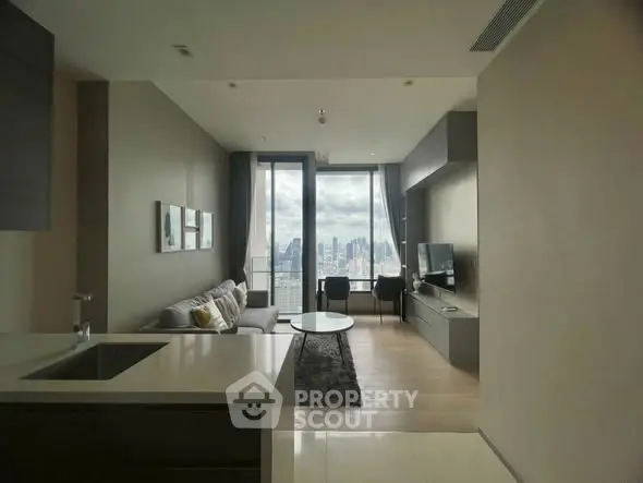 Modern living room with city view, featuring sleek furniture and large windows for natural light.