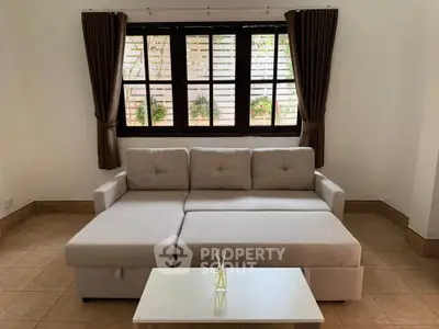 Cozy living room with stylish beige sofa and elegant curtains