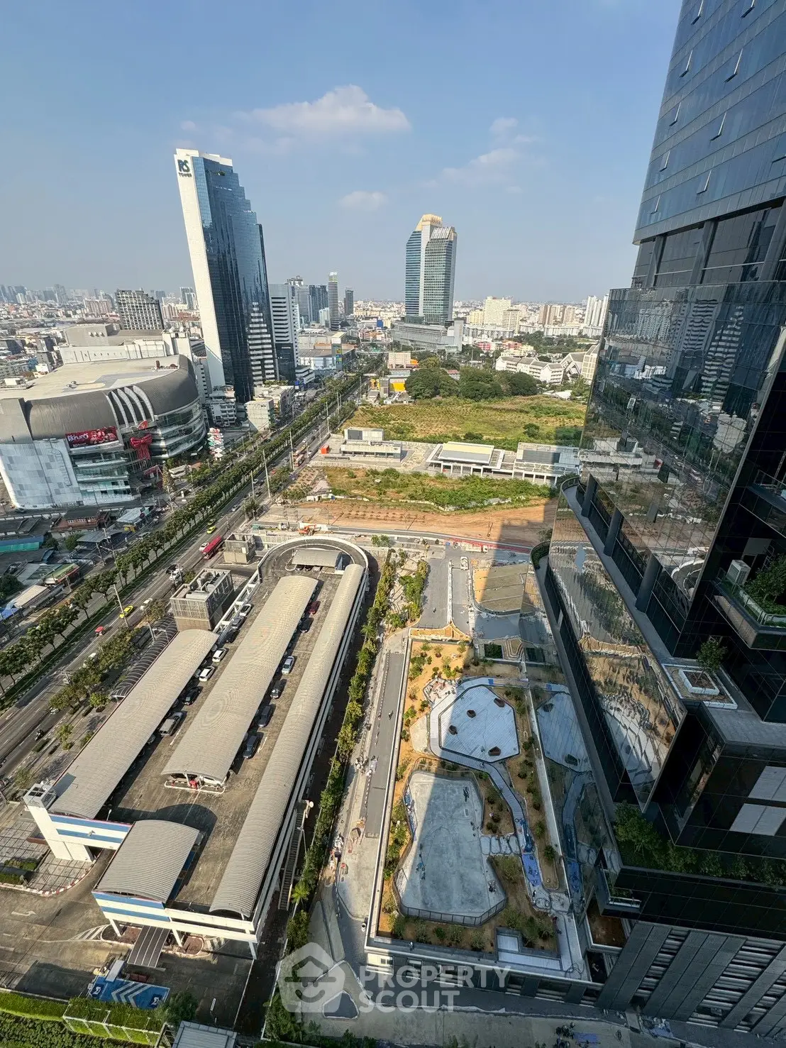 Stunning cityscape view from high-rise building with modern architecture and lush greenery.