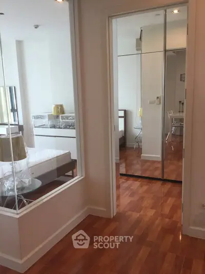 Modern bedroom with mirrored closet and wooden flooring in a stylish apartment
