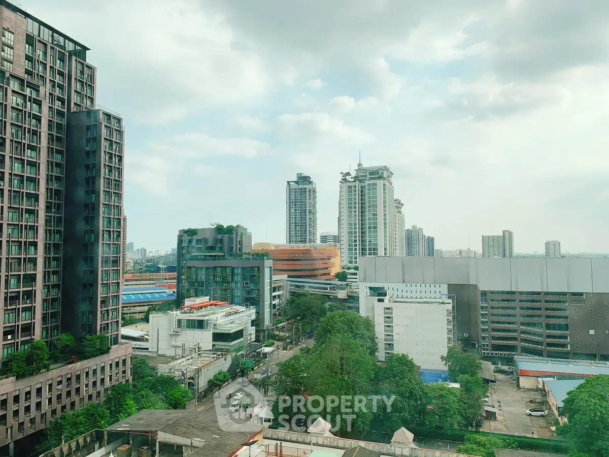 Stunning cityscape view from high-rise building with lush greenery and modern architecture.