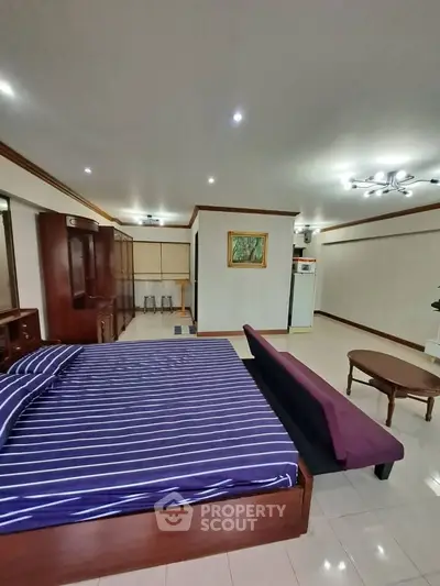 Spacious bedroom with modern furnishings and elegant lighting
