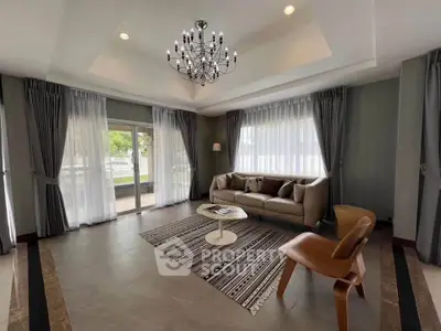 Elegant living room with chandelier and large windows for natural light