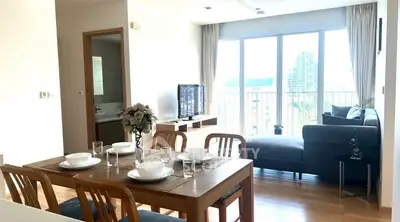 Bright modern living room with dining area and large windows in city apartment.