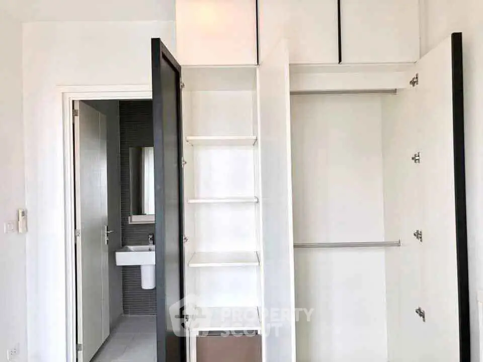 Spacious modern closet with open shelving and hanging space in a bright room.