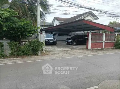 Spacious residential property with covered parking and lush greenery in a serene neighborhood.