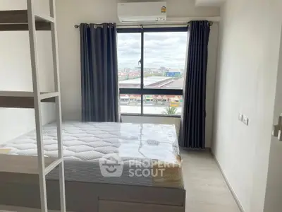 Modern bedroom with large window and air conditioning, offering a bright and cozy atmosphere.