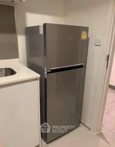 Modern kitchen with sleek stainless steel refrigerator and minimalist design.