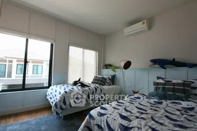 Charming bedroom with twin beds and large window offering natural light and neighborhood view.