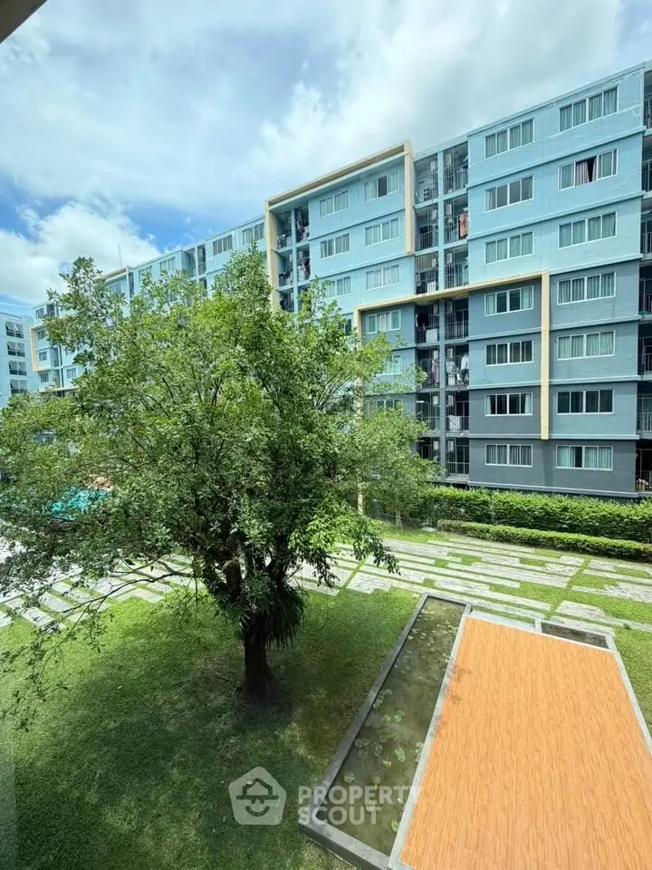 Modern apartment building with lush green surroundings and clear blue sky.