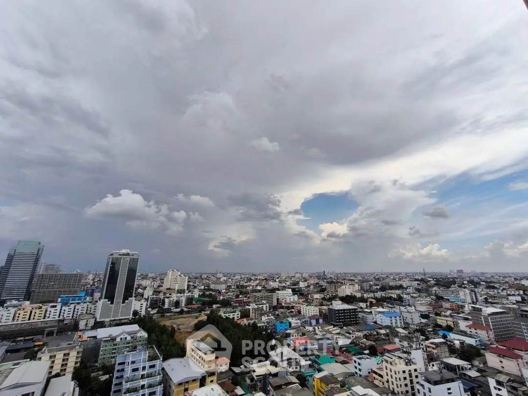 Stunning cityscape view from high-rise building showcasing urban skyline under dramatic clouds.