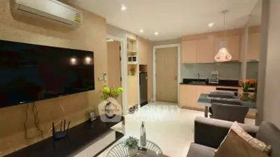 Modern living room with open kitchen, stylish decor, and cozy seating area in a contemporary apartment.