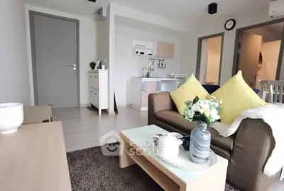 Modern living room with cozy sofa, stylish decor, and open kitchen layout in a contemporary apartment.