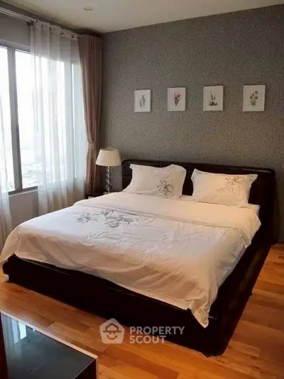 Cozy bedroom with elegant decor and large window offering natural light