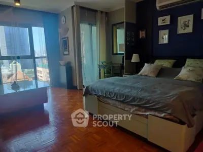 Spacious bedroom with large window and stylish decor in urban apartment