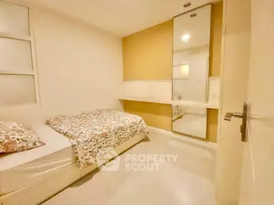 Cozy bedroom with modern decor and large mirror, perfect for relaxation.