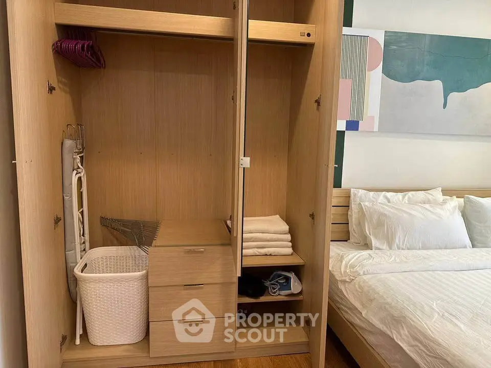 Spacious bedroom with modern wooden wardrobe and cozy bed setup.