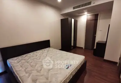 Spacious bedroom with modern furniture and wooden flooring in a stylish apartment.