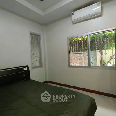 Cozy bedroom with air conditioning and garden view, perfect for relaxation.