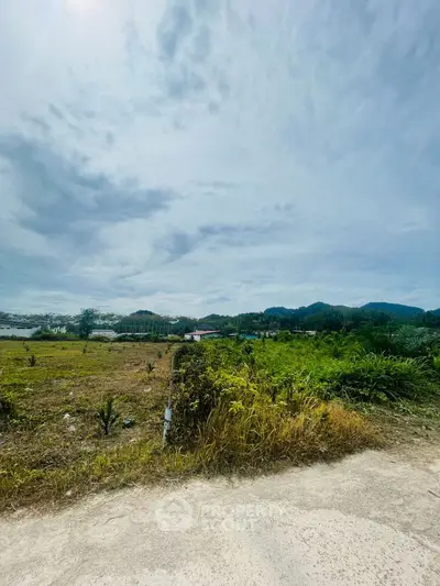 Expansive land plot with scenic mountain views under a vast sky, ideal for development.