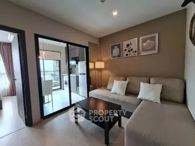 Modern living room with cozy sofa, open kitchen, and balcony view in stylish apartment.