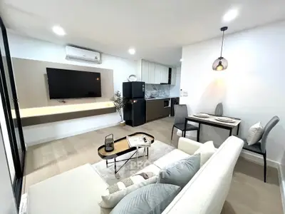 Modern living room with open kitchen, sleek furniture, and stylish decor in a contemporary apartment.