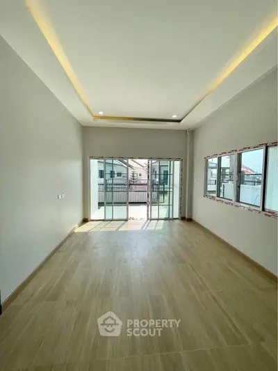 Spacious unfurnished room with large windows and balcony access, perfect for customization.