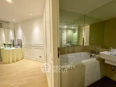 Elegant bathroom with bathtub and adjacent stylish living area in modern apartment.