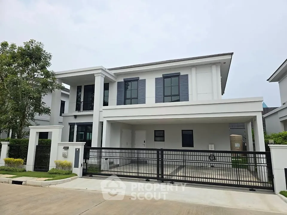 Modern two-story house with sleek design and spacious driveway in a serene neighborhood.