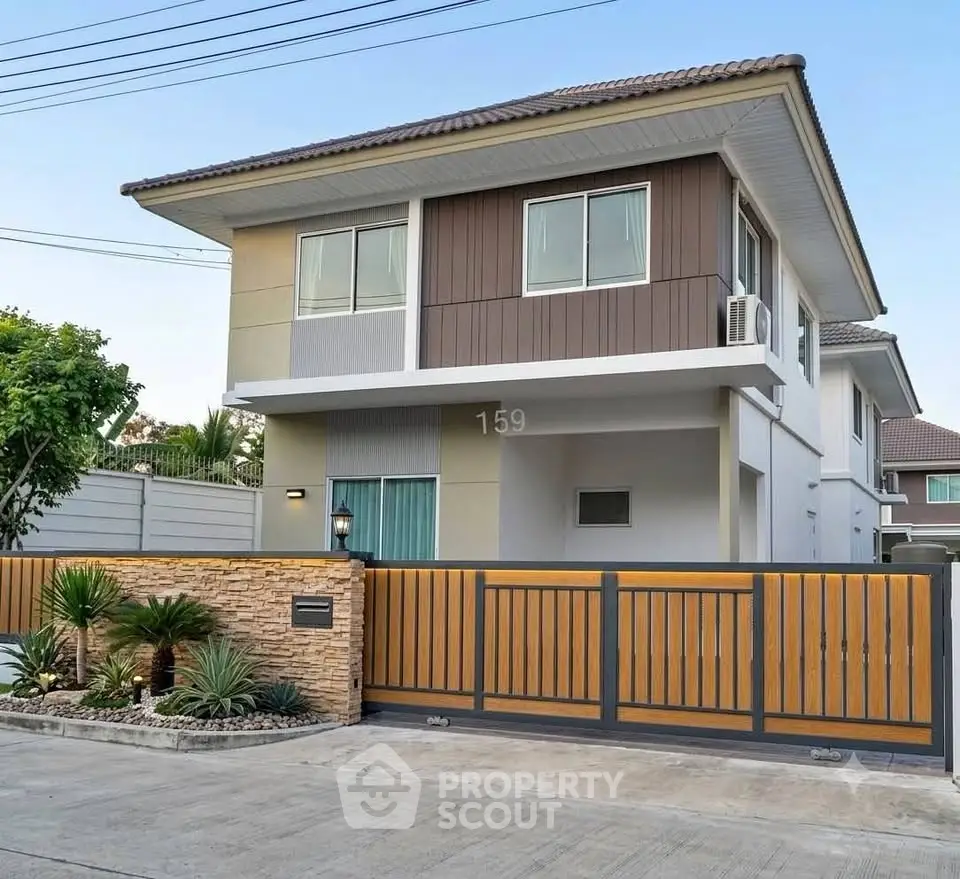 Modern two-story house with stylish facade and gated entrance in a serene neighborhood.