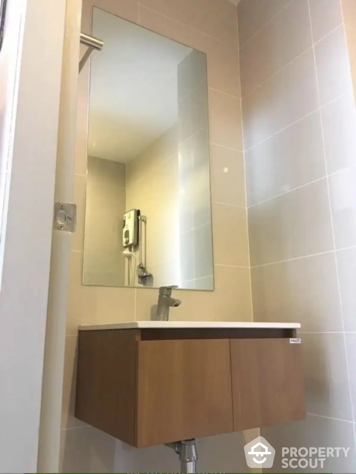 Modern bathroom with sleek vanity and large mirror in minimalist design.