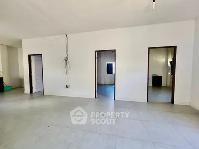 Spacious interior with multiple doorways and tiled flooring, ideal for customization.