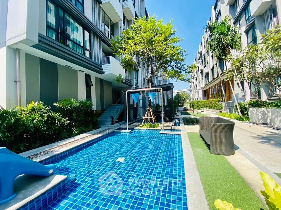 Modern apartment complex with pool and lush greenery