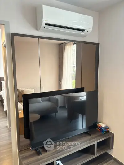Modern living room with sleek TV setup and air conditioning unit