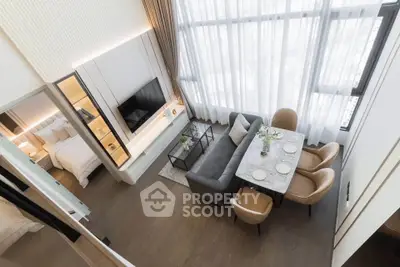 Modern duplex apartment with open living and dining area, featuring high ceilings and large windows.