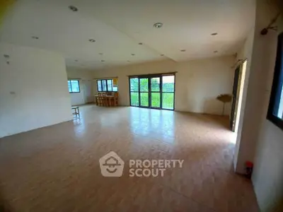 Spacious open-plan living area with large windows and garden view.