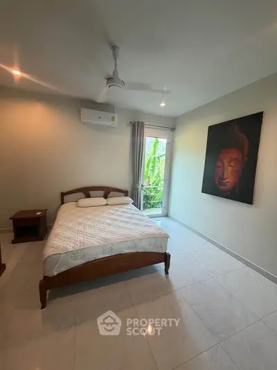 Spacious bedroom with modern decor and serene artwork, featuring a cozy bed and natural light from a large window.