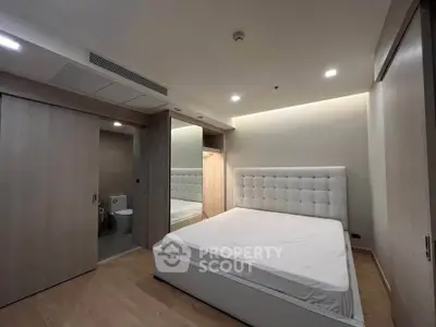 Modern bedroom with elegant design and ensuite bathroom in luxury apartment.