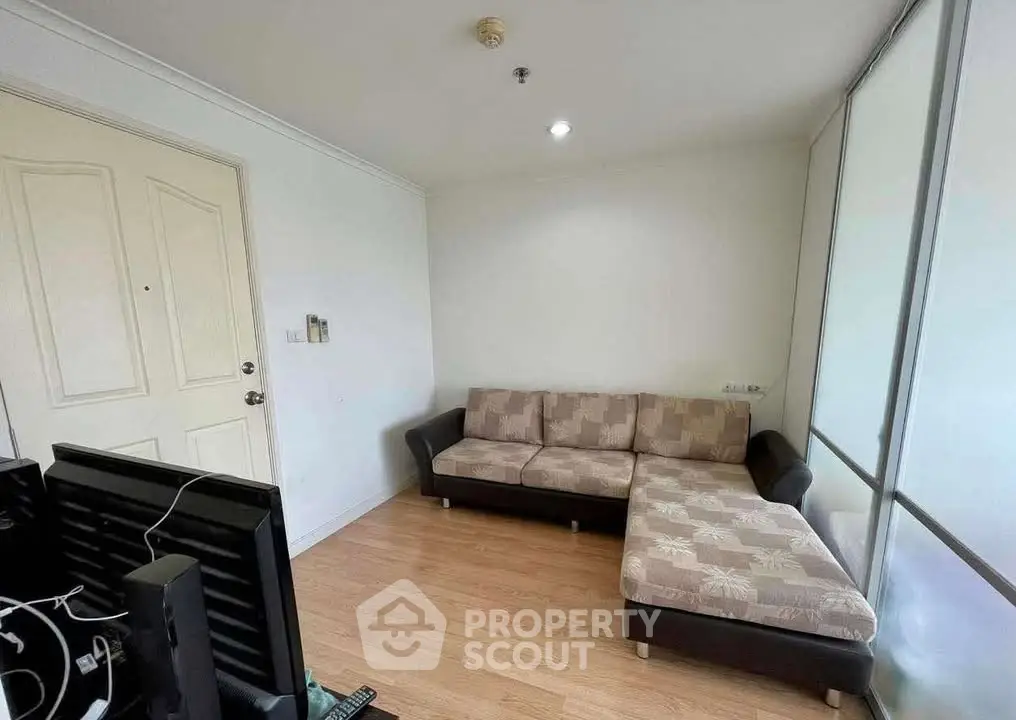 Cozy living room with modern sofa and wooden flooring in a bright apartment.