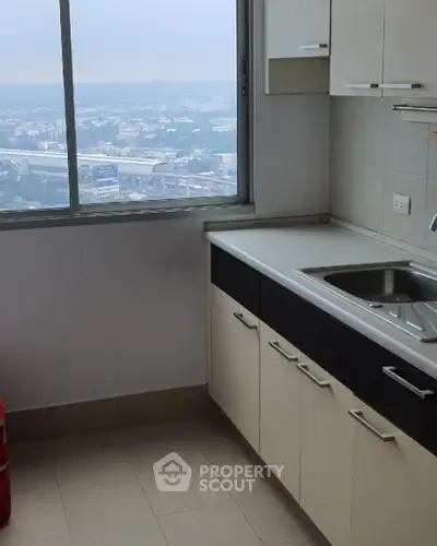 Modern kitchen with stunning city view from high-rise apartment window.