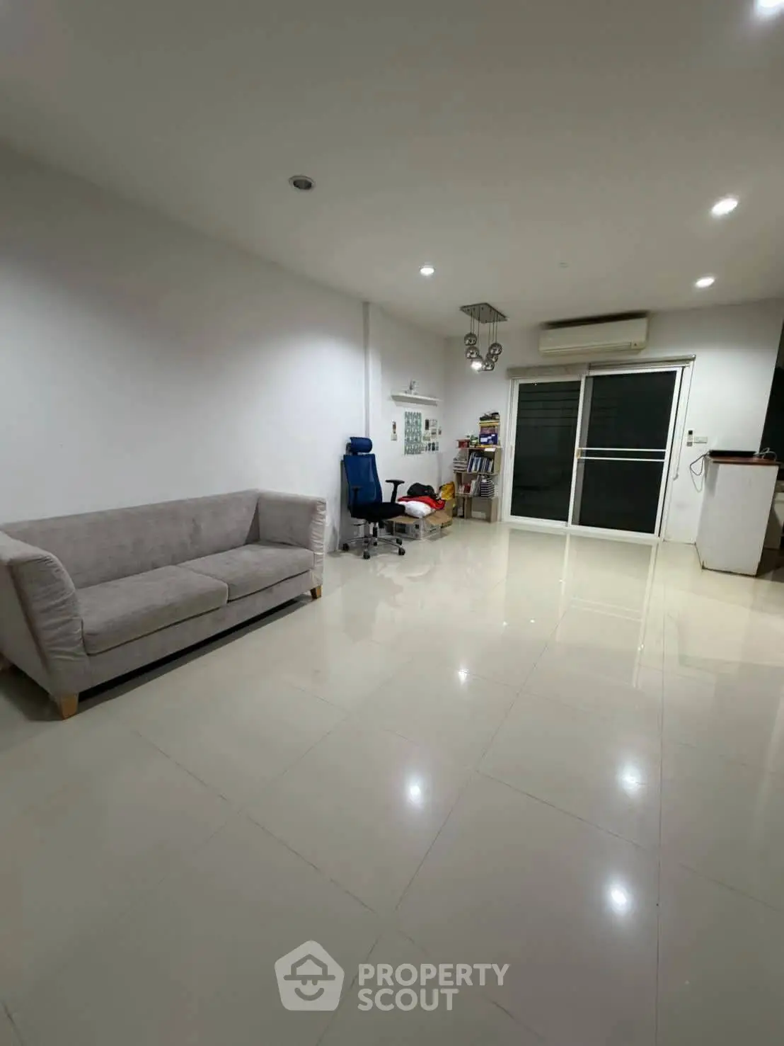 Spacious living room with modern furniture and sleek tiled flooring, perfect for relaxation and entertainment.