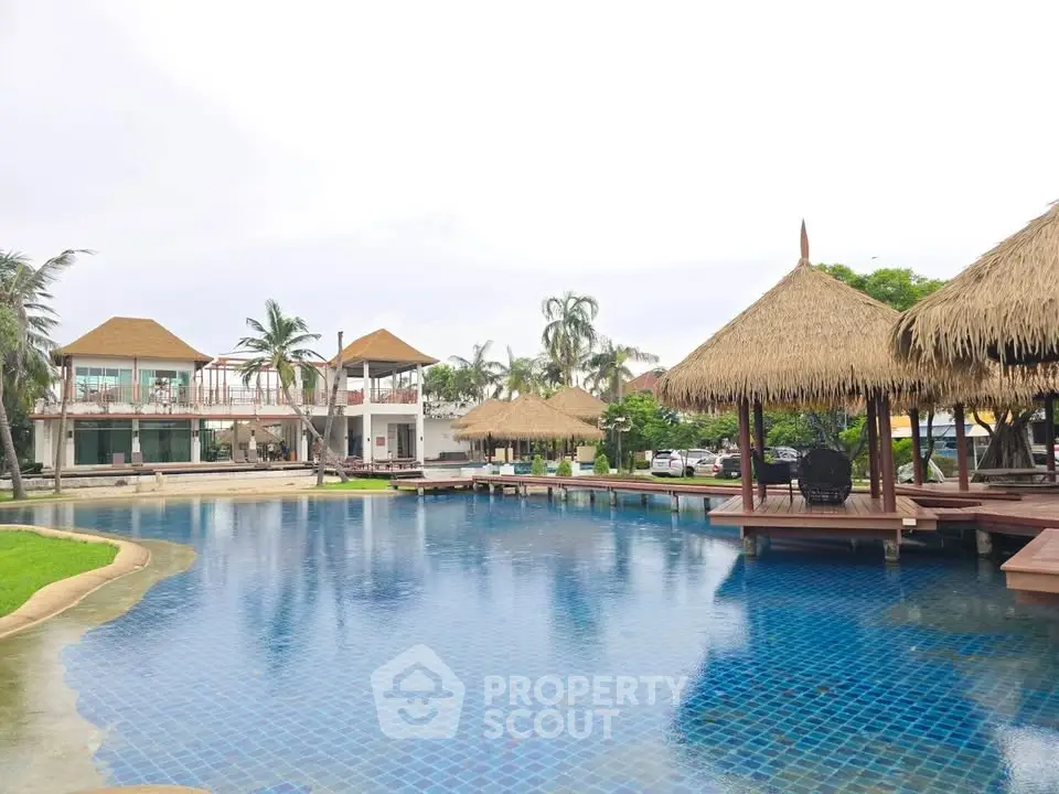 Luxurious tropical resort with stunning pool and thatched-roof cabanas, perfect for relaxation and leisure.